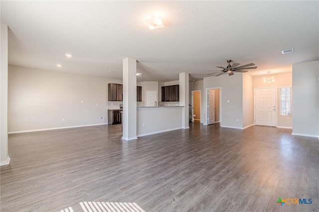 unfurnished living room with a ceiling fan, wood finished floors, visible vents, and baseboards