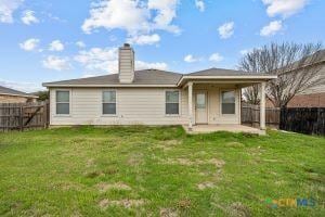 back of property featuring a lawn and a patio area