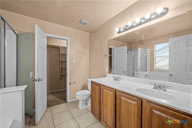 bathroom featuring tile patterned floors, vanity, toilet, and an enclosed shower