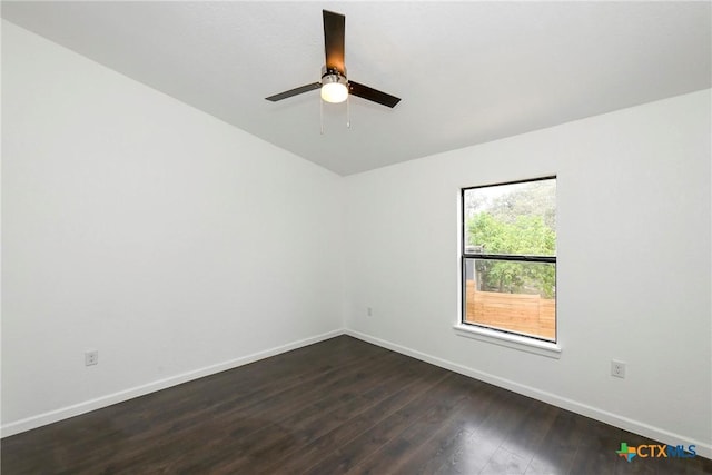 unfurnished room featuring dark wood finished floors, a ceiling fan, and baseboards