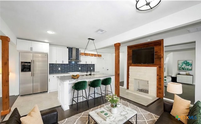 interior space featuring a stone fireplace, decorative columns, and visible vents