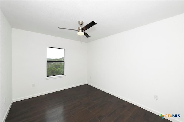 empty room with baseboards, dark wood-style floors, and a ceiling fan