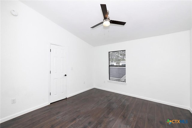 unfurnished room featuring baseboards, dark wood-type flooring, a ceiling fan, and vaulted ceiling