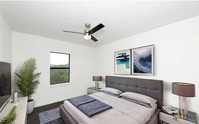 bedroom featuring wood finished floors, baseboards, and ceiling fan