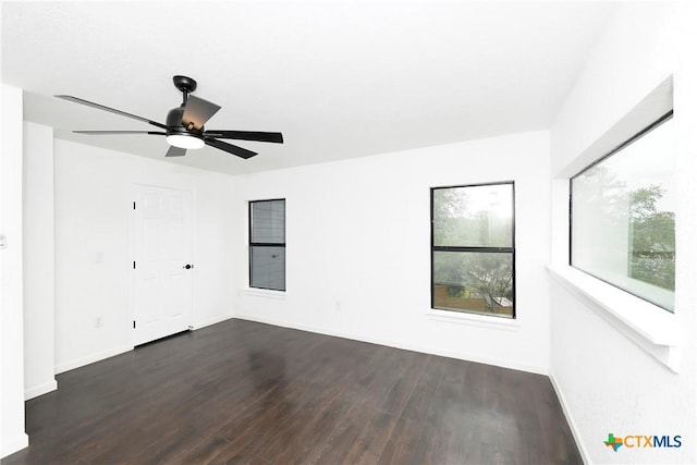 spare room with ceiling fan and dark hardwood / wood-style flooring