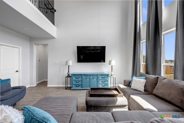 living room with hardwood / wood-style flooring and a towering ceiling