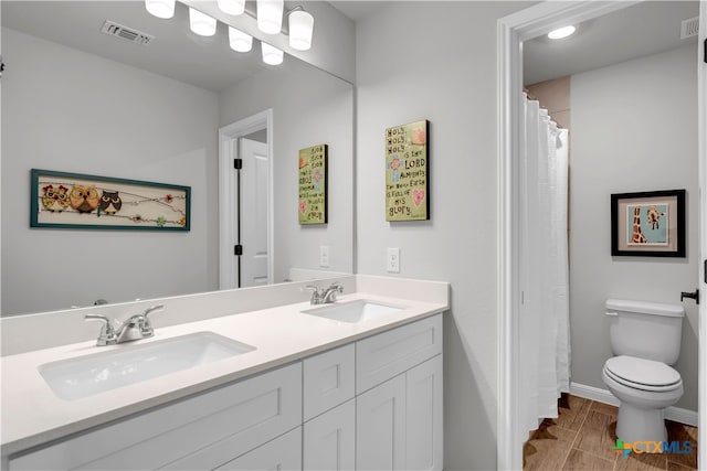 bathroom featuring toilet, vanity, and hardwood / wood-style floors