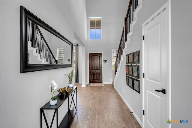 foyer entrance featuring hardwood / wood-style flooring and a high ceiling