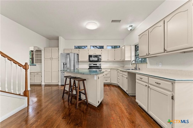 1560 Roadrunner Ln, Canyon Lake, TX 78133 - kitchen with stainless steel appliances, a kitchen breakfast bar, dark wood finished floors, and a kitchen island
