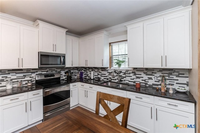 235 Gray St, San Antonio, TX 78208 - kitchen with appliances with stainless steel finishes, a sink, decorative backsplash, and white cabinetry