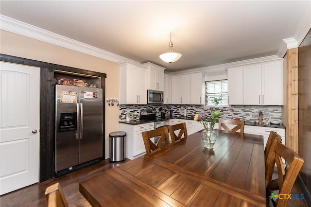 235 Gray St, San Antonio, TX 78208 - kitchen with appliances with stainless steel finishes, dark countertops, white cabinets, decorative backsplash, and crown molding