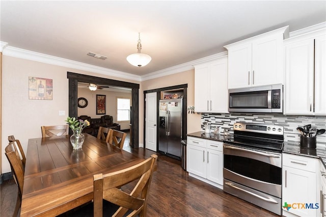 235 Gray St, San Antonio, TX 78208 - kitchen featuring stainless steel appliances, dark countertops, crown molding, white cabinets, and tasteful backsplash