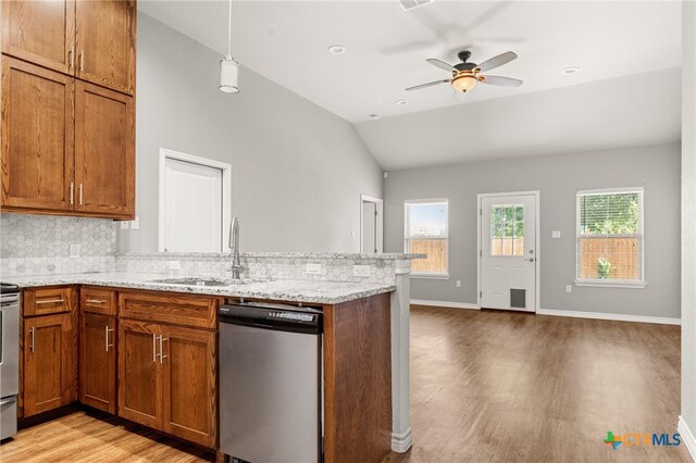 152 Navarro Xing Unit 3B, Seguin, TX 78155 - kitchen with dishwasher, light wood-type flooring, brown cabinets, vaulted ceiling, and a peninsula
