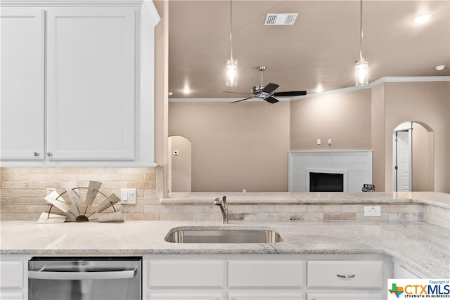 kitchen with stainless steel dishwasher, light stone counters, and white cabinetry