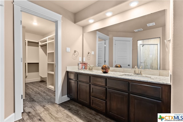 bathroom featuring a shower, vanity, and hardwood / wood-style flooring