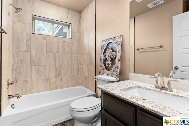 full bathroom with vanity, tiled shower / bath combo, and toilet