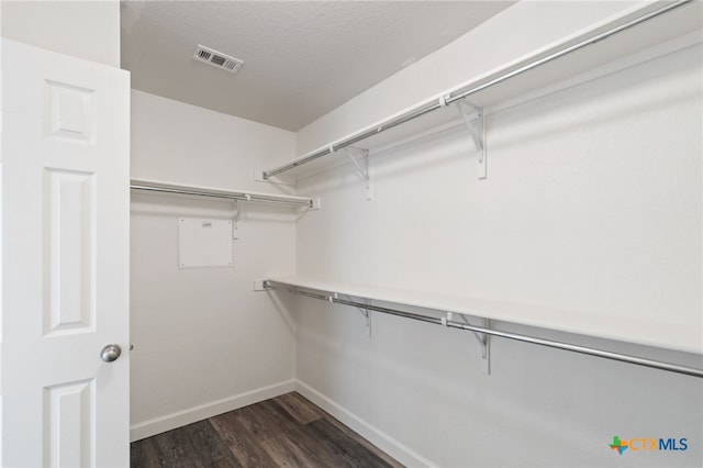 spacious closet with dark wood finished floors and visible vents