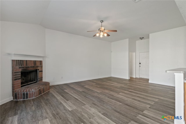 unfurnished living room featuring baseboards, a fireplace, a ceiling fan, and wood finished floors