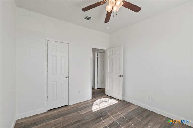 unfurnished bedroom featuring baseboards, a ceiling fan, wood finished floors, and visible vents