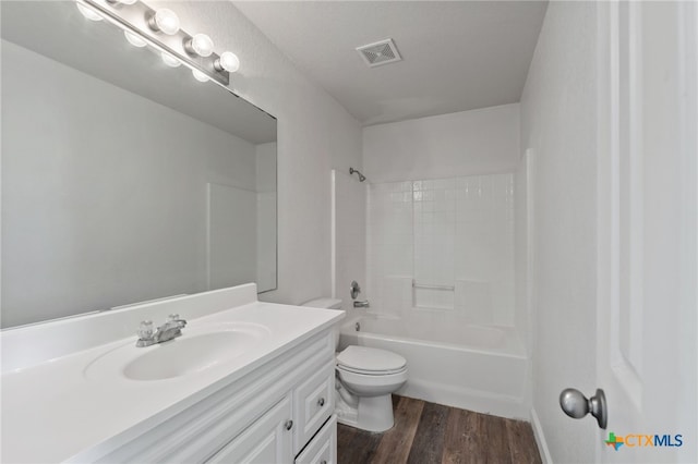 full bathroom featuring visible vents, vanity, wood finished floors, toilet, and shower / tub combination