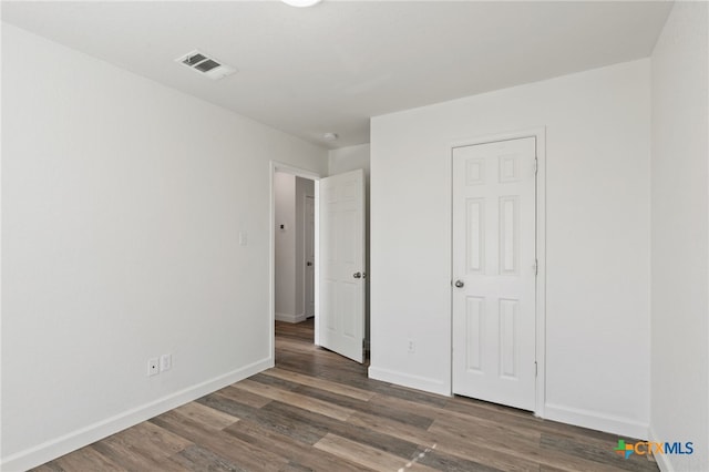 unfurnished bedroom with baseboards, wood finished floors, and visible vents
