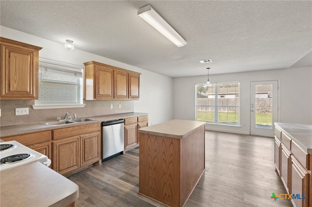 kitchen with a sink, a kitchen island, a textured ceiling, and dishwasher