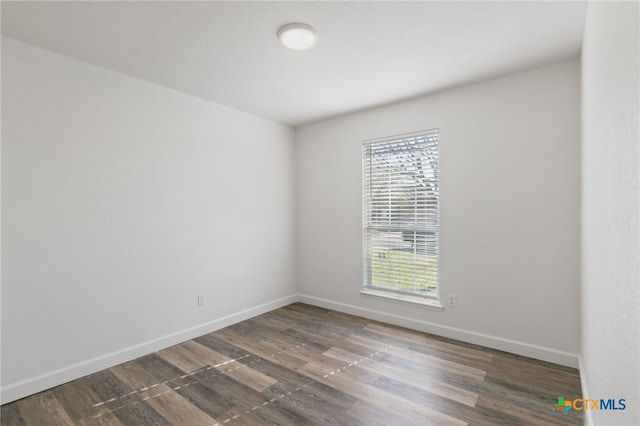 empty room featuring baseboards and wood finished floors