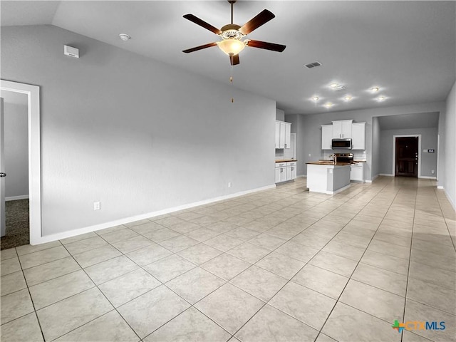 1938 Reserve Way, New Braunfels, TX 78130 - unfurnished living room featuring ceiling fan, baseboards, vaulted ceiling, and light tile patterned flooring