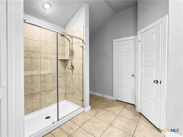 1938 Reserve Way, New Braunfels, TX 78130 - bathroom featuring a shower stall, tile patterned flooring, vaulted ceiling, baseboards, and a textured ceiling