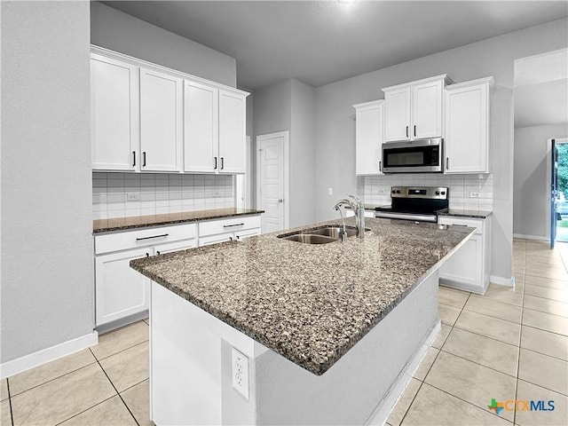1938 Reserve Way, New Braunfels, TX 78130 - kitchen featuring stainless steel appliances, a sink, backsplash, light tile patterned floors, and dark stone counters