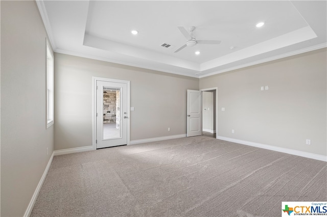 carpeted empty room with crown molding, ceiling fan, and a raised ceiling