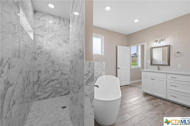 bathroom with hardwood / wood-style floors, vanity, and independent shower and bath