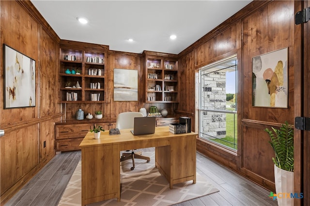 office area featuring wooden walls, light hardwood / wood-style floors, and plenty of natural light