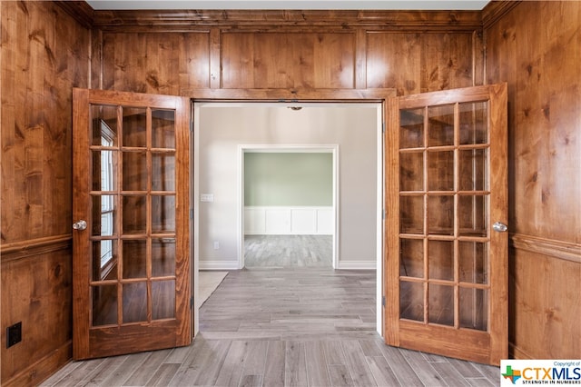 interior space featuring light wood-type flooring and wooden walls