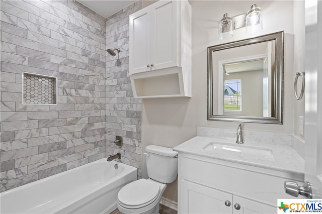 full bathroom featuring vanity, tiled shower / bath, and toilet