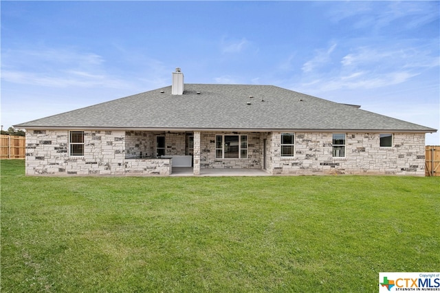 rear view of house with a patio and a yard