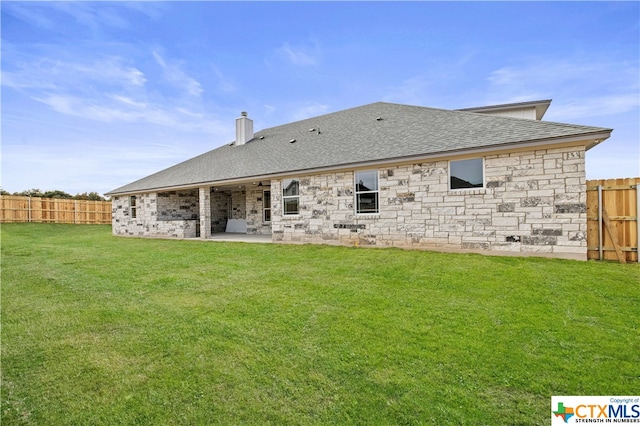 rear view of property featuring a yard and a patio area