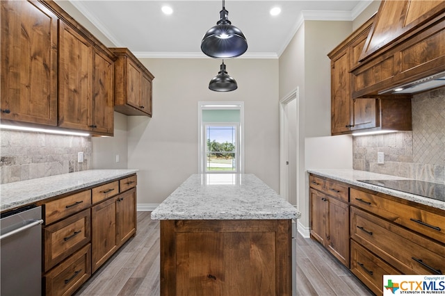 kitchen with crown molding, light hardwood / wood-style floors, hanging light fixtures, and a kitchen island