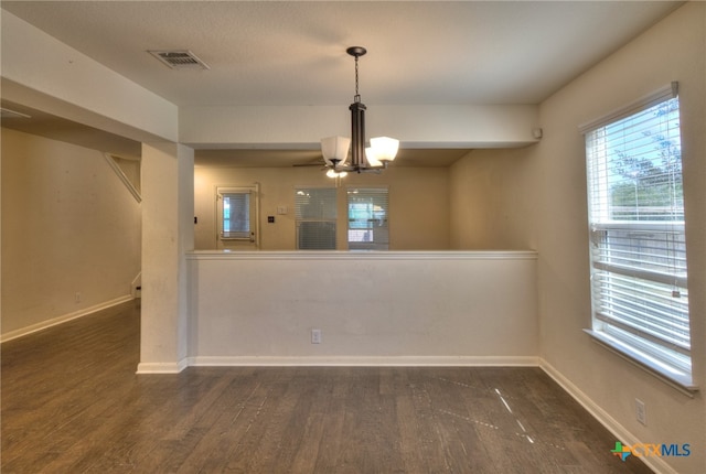 unfurnished dining area with an inviting chandelier and dark hardwood / wood-style floors