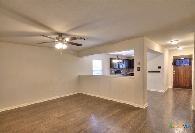 interior space featuring a textured ceiling, ceiling fan with notable chandelier, and dark hardwood / wood-style floors