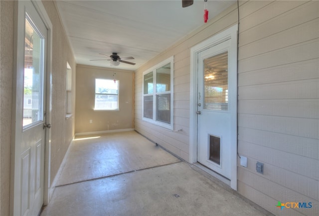 unfurnished sunroom with ceiling fan