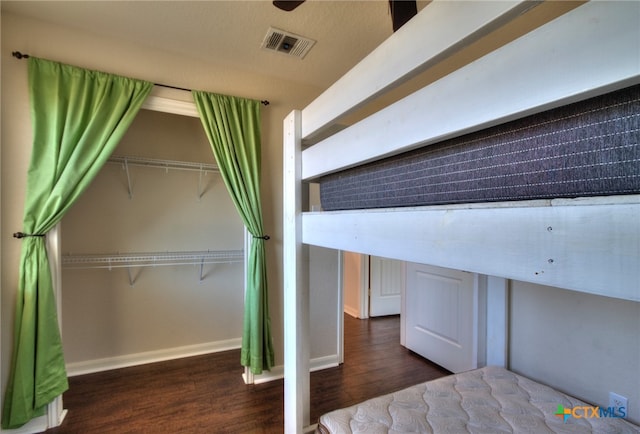 unfurnished bedroom with dark wood-type flooring and a closet