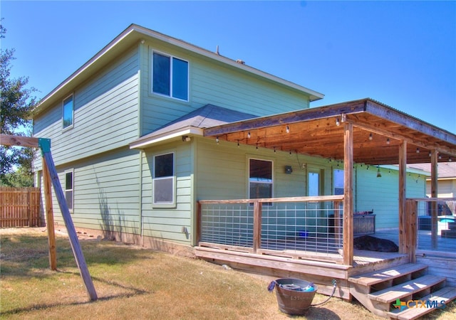 back of property featuring a yard and a wooden deck