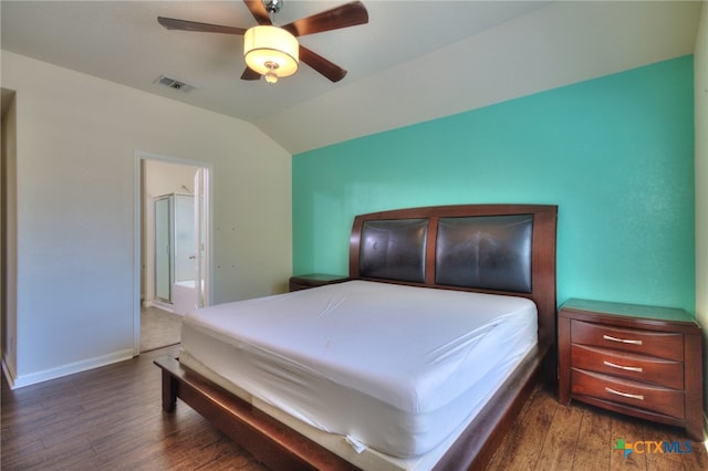 bedroom featuring ensuite bathroom, dark hardwood / wood-style floors, ceiling fan, and vaulted ceiling