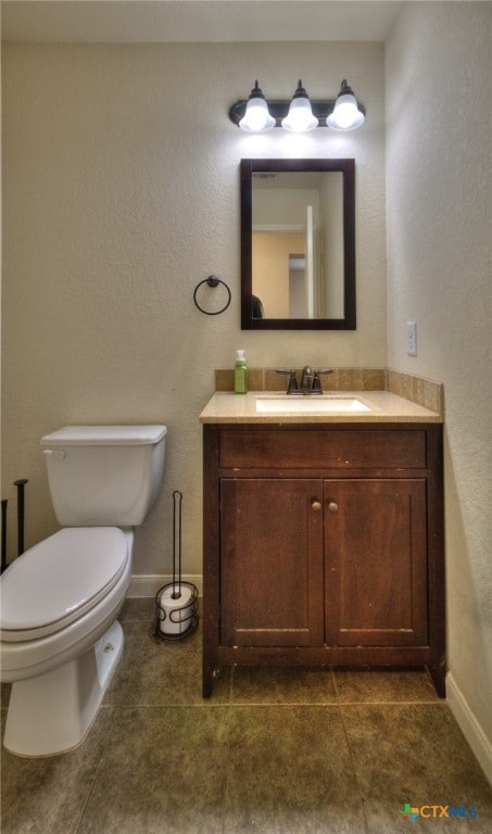 bathroom with tile patterned floors, vanity, and toilet