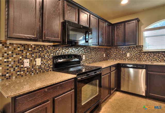 kitchen featuring dark brown cabinetry, light tile patterned floors, black appliances, and backsplash