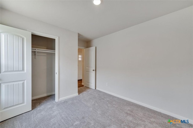 unfurnished bedroom with baseboards, a closet, and carpet flooring