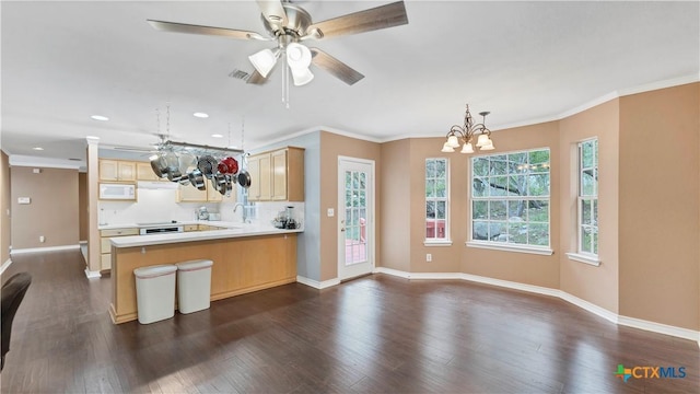 kitchen featuring light brown cabinets, an inviting chandelier, sink, decorative light fixtures, and kitchen peninsula