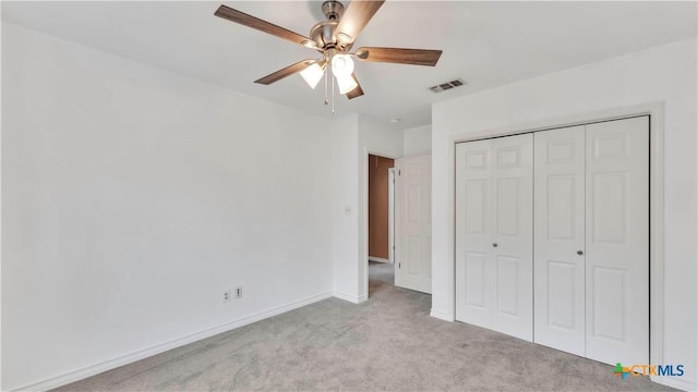 unfurnished bedroom featuring light carpet, a closet, and ceiling fan