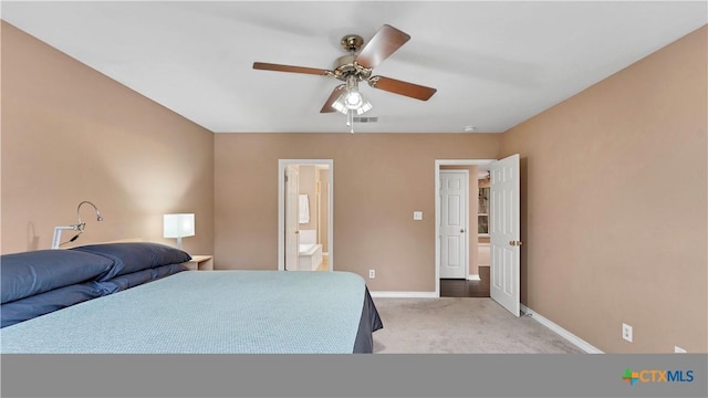 bedroom with ceiling fan, ensuite bathroom, and light carpet